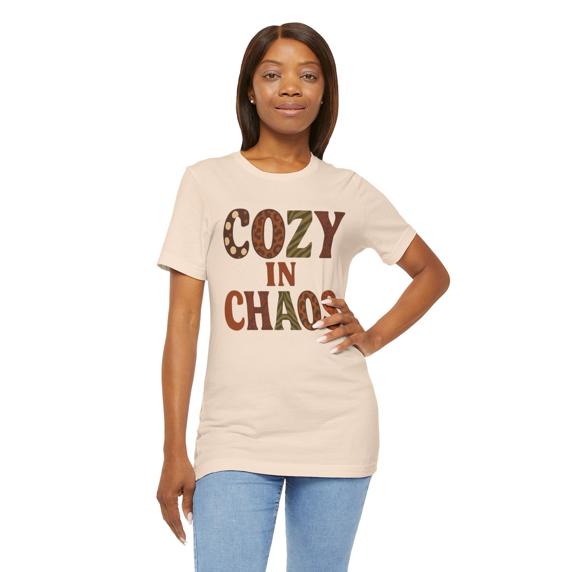 Woman wearing a beige t-shirt with 'COZY IN CHAOS' text on a white background