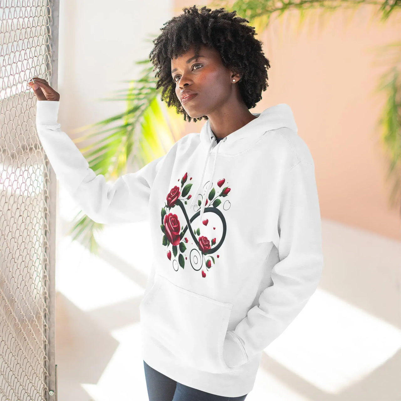 Person wearing a white hoodie with a unique design, standing against a light background.
