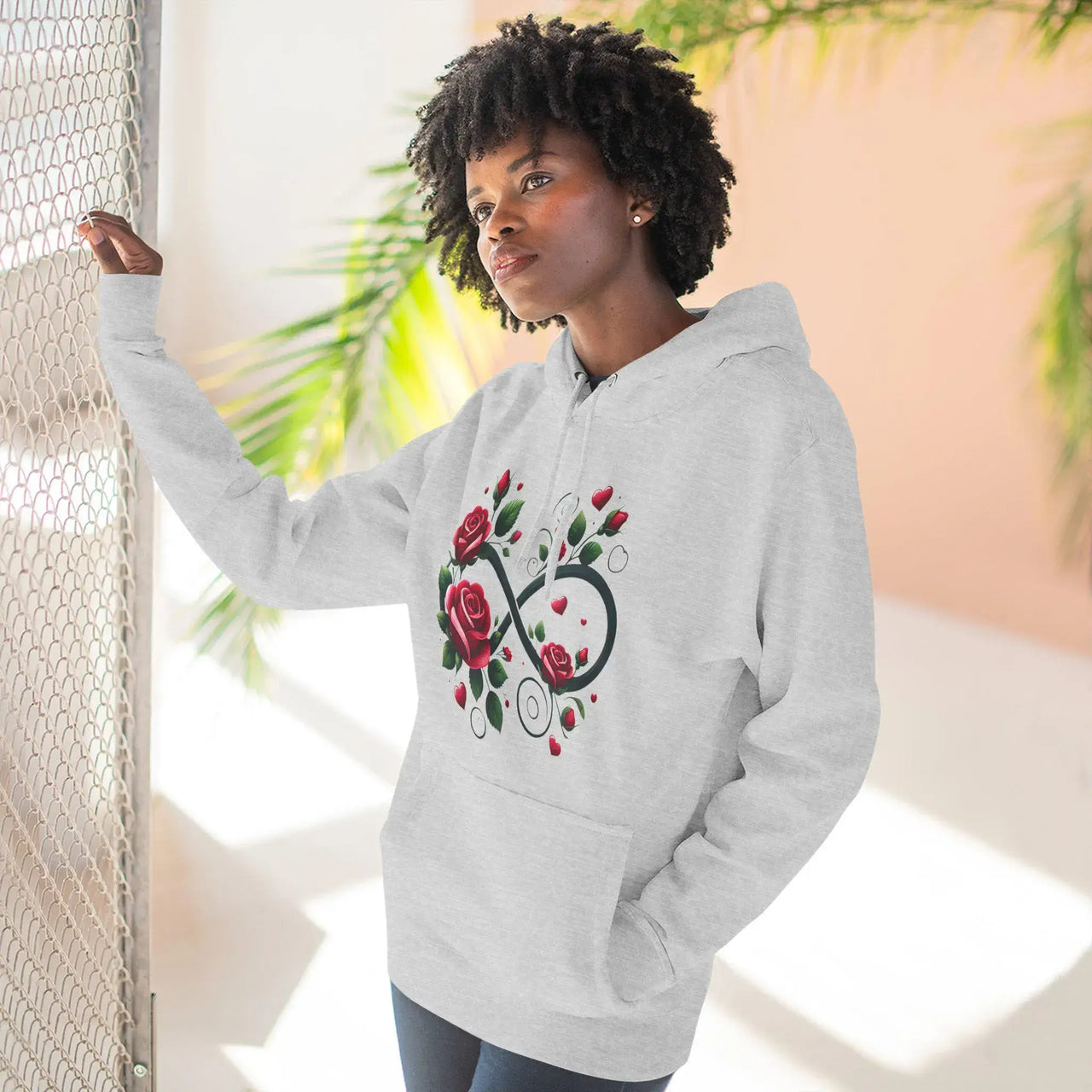Person wearing a gray hoodie with a unique design, standing against a light background.