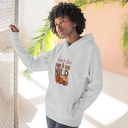 Person wearing a gray hoodie with a graphic design, standing indoors with plants in the background.